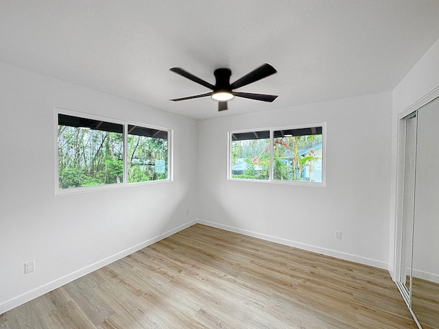 unfurnished bedroom featuring a closet, ceiling fan, light hardwood / wood-style floors, and a textured ceiling