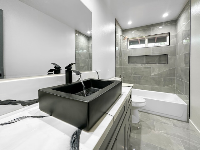 full bathroom featuring tiled shower / bath, toilet, and vanity