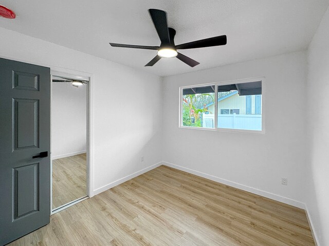 unfurnished bedroom with light wood-type flooring, a closet, and ceiling fan