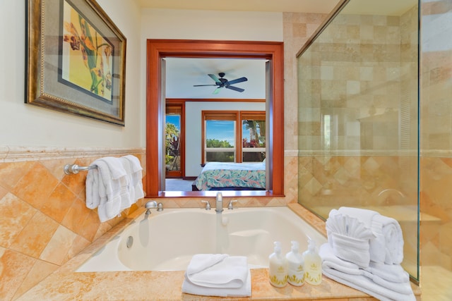 bathroom featuring ceiling fan and tiled bath