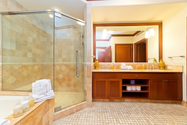 bathroom featuring tile patterned flooring, ornamental molding, dual vanity, and a shower with door