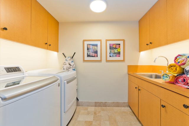 laundry room with light tile patterned floors, sink, washer and dryer, and cabinets