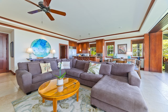 tiled living room featuring ceiling fan, a raised ceiling, and ornamental molding