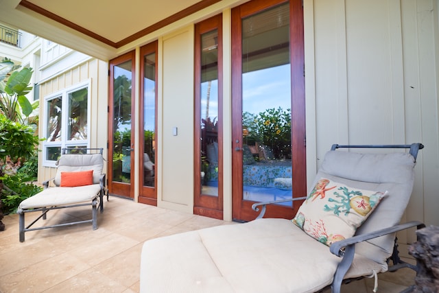 exterior space with french doors, crown molding, and light tile patterned floors