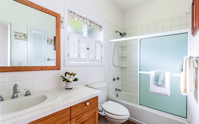 full bathroom with shower / bath combination with glass door, vanity, and toilet