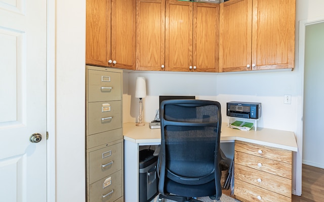 office space with built in desk and hardwood / wood-style flooring