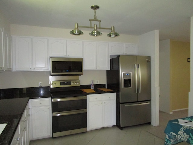 kitchen with decorative light fixtures, appliances with stainless steel finishes, light tile patterned floors, and white cabinetry