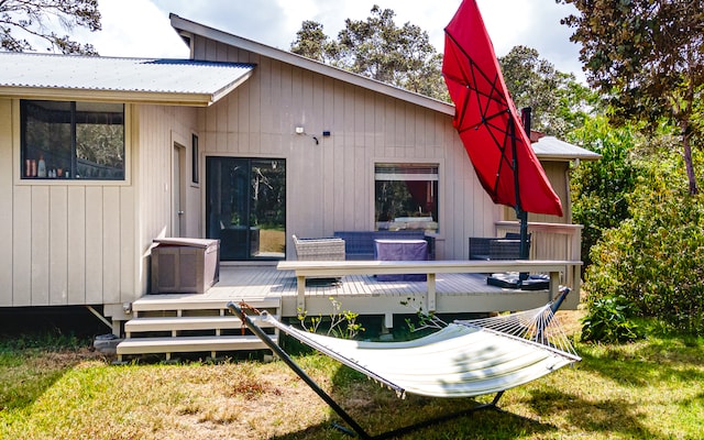 rear view of house with a wooden deck and a yard