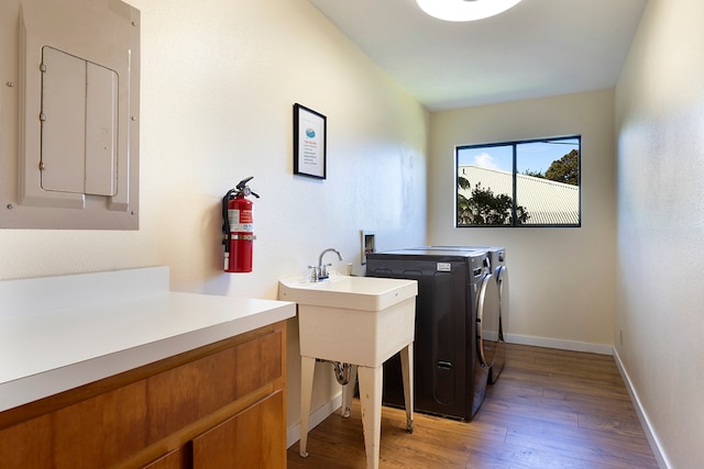 laundry area featuring electric panel, dark hardwood / wood-style floors, and washing machine and clothes dryer