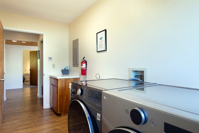 laundry area with separate washer and dryer, cabinets, electric panel, and dark hardwood / wood-style floors