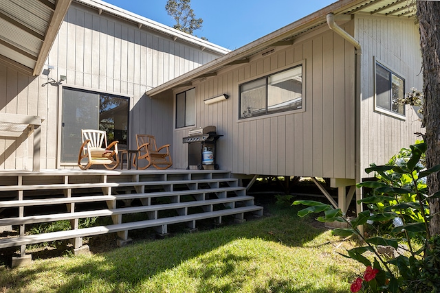 rear view of property featuring a deck and a lawn