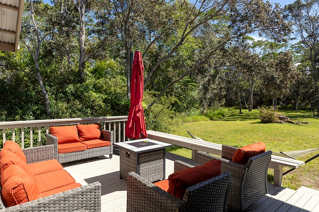 wooden terrace featuring an outdoor living space with a fire pit and a lawn