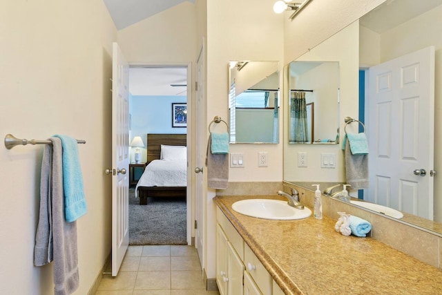 bathroom featuring tile patterned flooring, lofted ceiling, and vanity