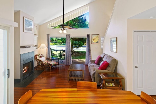 living room featuring ceiling fan, vaulted ceiling, dark hardwood / wood-style floors, and a tile fireplace