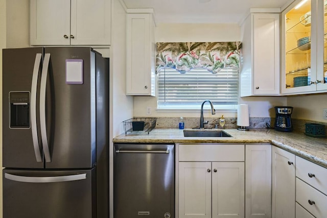 kitchen featuring sink, white cabinetry, light stone counters, and stainless steel appliances