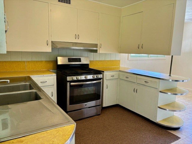 kitchen featuring tasteful backsplash and stainless steel range with gas stovetop