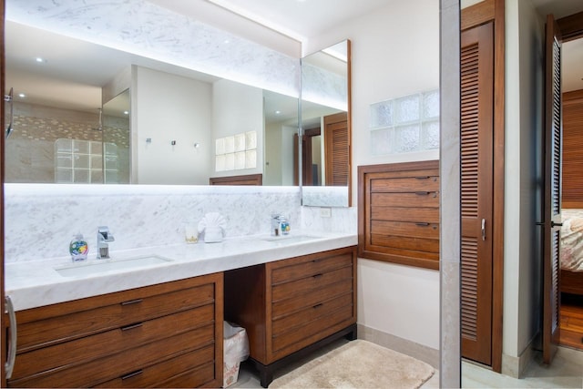 full bath with double vanity, tasteful backsplash, a closet, and a sink