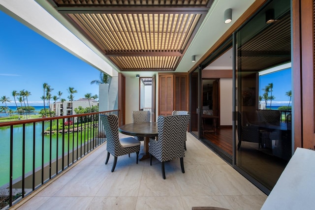 balcony featuring a water view and a pergola