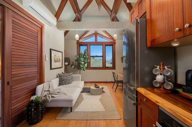 living room featuring a wall mounted AC, light hardwood / wood-style floors, and vaulted ceiling with beams