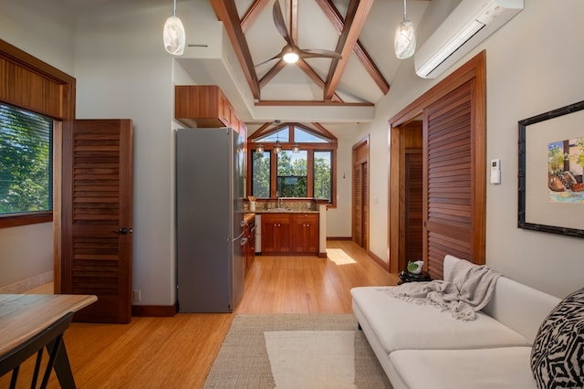 living room featuring vaulted ceiling with beams, light hardwood / wood-style flooring, sink, and a wall mounted air conditioner