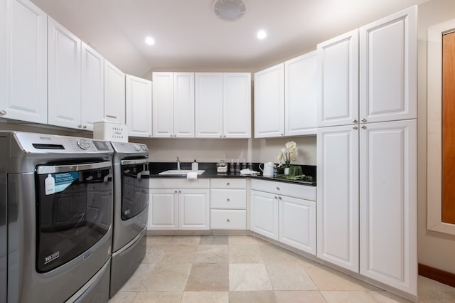 clothes washing area featuring light tile patterned flooring, sink, cabinets, and independent washer and dryer