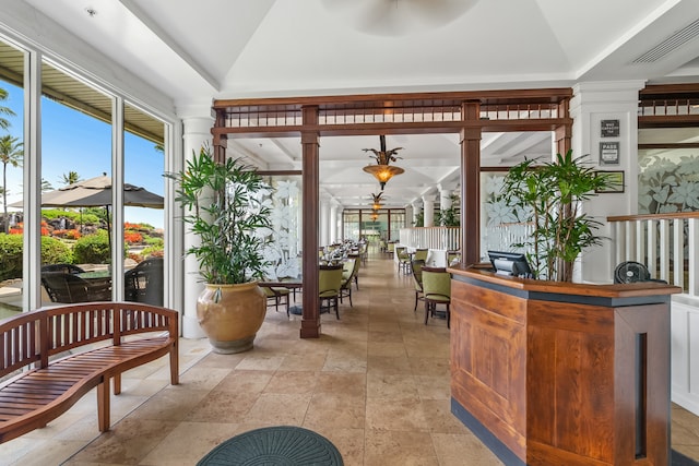 reception area with ceiling fan and ornate columns