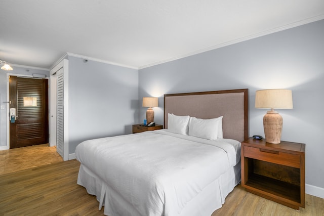 bedroom with crown molding, hardwood / wood-style flooring, and a closet