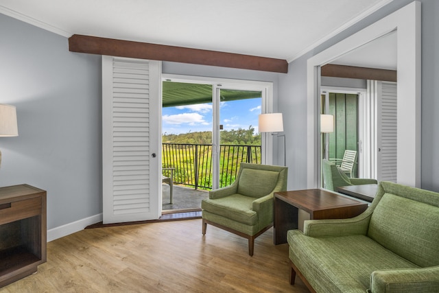 sitting room featuring crown molding and light hardwood / wood-style flooring