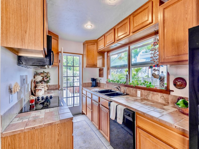 kitchen featuring light tile patterned floors, sink, black appliances, and tile countertops