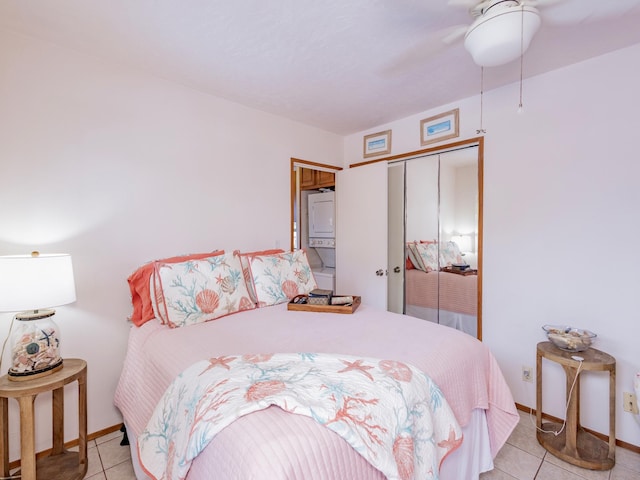 bedroom with tile patterned flooring, baseboards, ceiling fan, and a closet