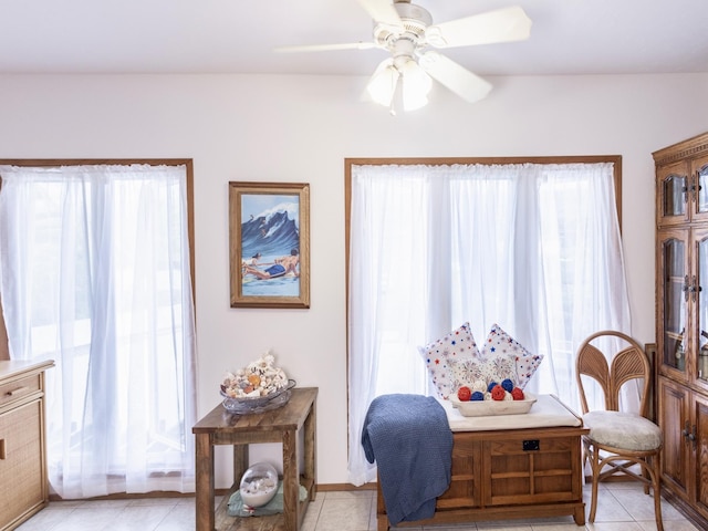 sitting room with a ceiling fan and light tile patterned flooring