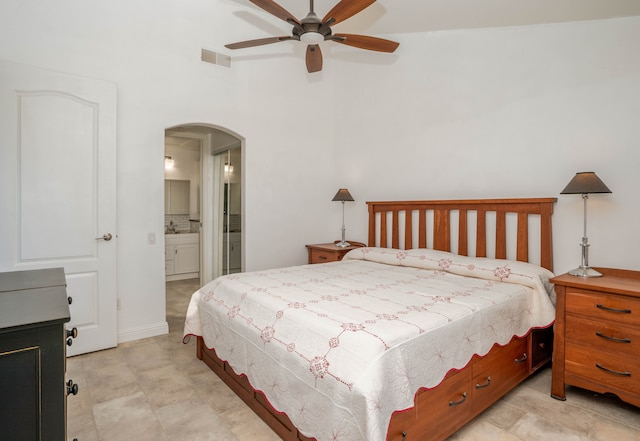 tiled bedroom featuring ceiling fan and ensuite bath