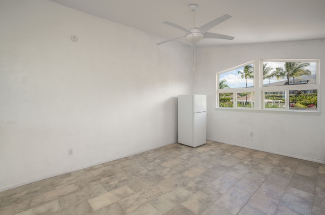 tiled empty room featuring vaulted ceiling and ceiling fan