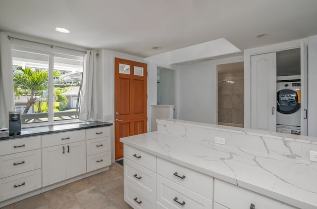 bathroom with washer / dryer and tile patterned flooring