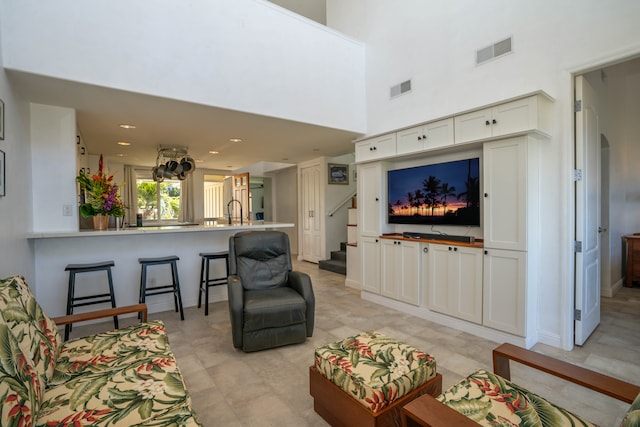 living room featuring a towering ceiling and light tile patterned floors