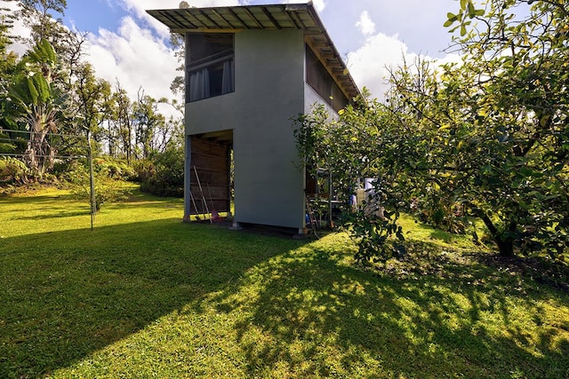 view of home's exterior with an outbuilding, a yard, and stucco siding