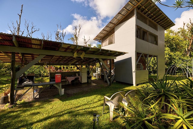 exterior space with stucco siding, a lawn, and a pergola