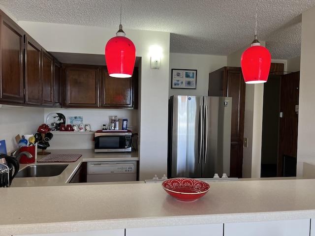 101 Hilo Lagoon Ctr Unit 401, Hilo, HI 96720 - kitchen featuring appliances with stainless steel finishes, a sink, a textured ceiling, dark brown cabinets, and pendant lighting