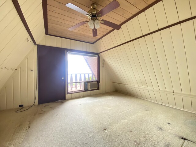 bonus room featuring ceiling fan, wood ceiling, wooden walls, and carpet flooring