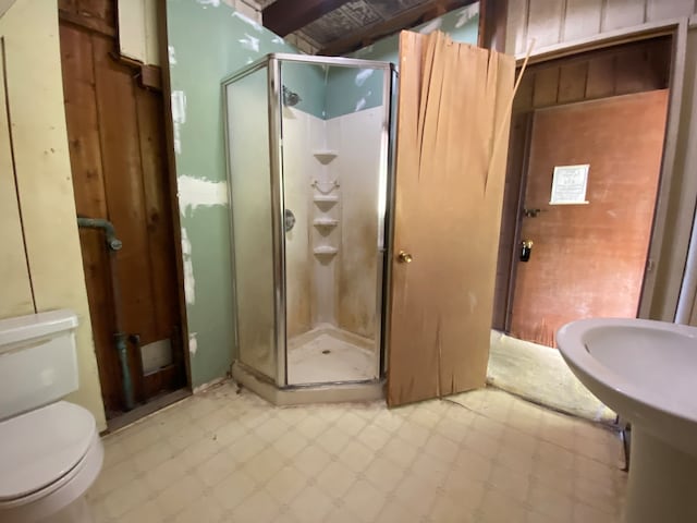 bathroom with tile patterned flooring, toilet, and an enclosed shower