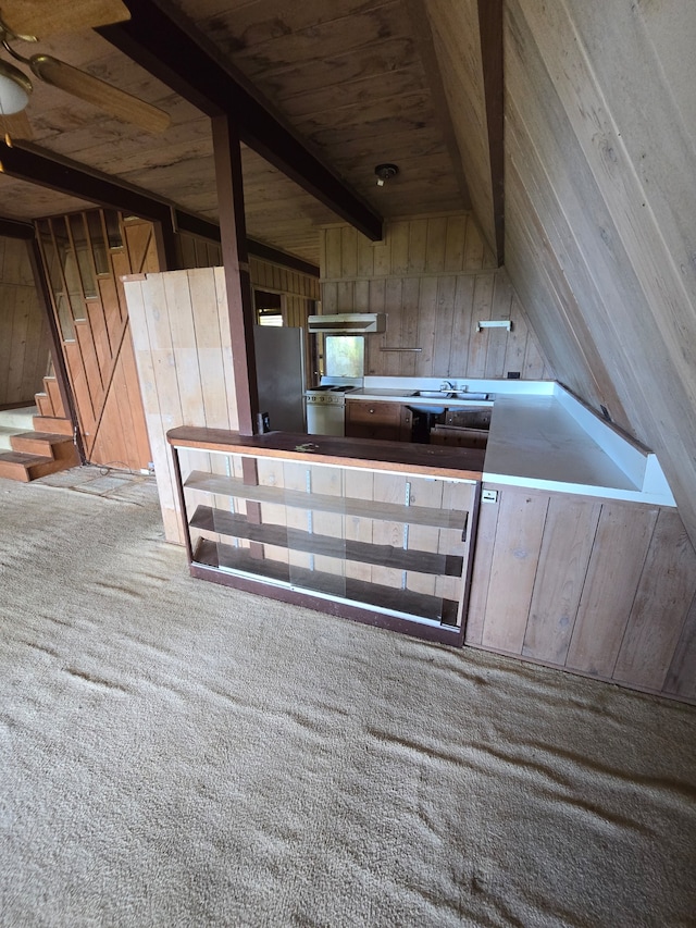 kitchen featuring wood walls, wooden ceiling, carpet floors, stainless steel fridge, and lofted ceiling with beams