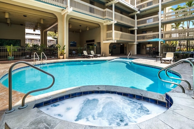 view of pool with a hot tub