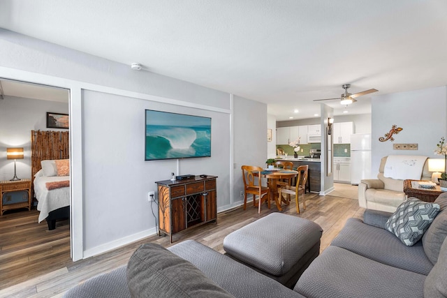 living room featuring light wood-type flooring and ceiling fan