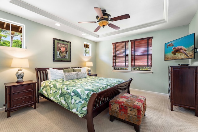 carpeted bedroom featuring ceiling fan and a raised ceiling