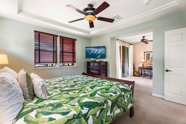 carpeted bedroom with a tray ceiling, ceiling fan, and crown molding