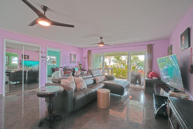 living area with ceiling fan and a textured ceiling