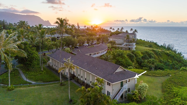 aerial view at dusk featuring a water view