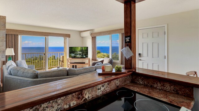 living room with plenty of natural light, a textured ceiling, and a wall mounted air conditioner