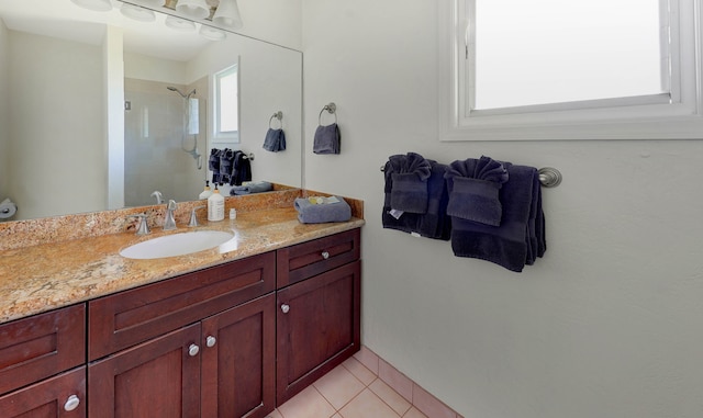 bathroom featuring tiled shower, tile patterned floors, and vanity