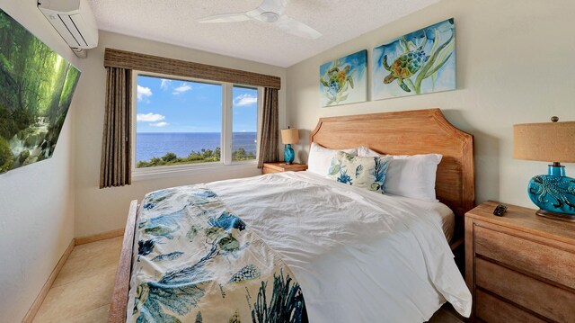 tiled bedroom featuring ceiling fan, a textured ceiling, an AC wall unit, and a water view